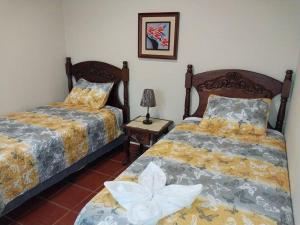 科马亚瓜Casa en Comayagua cerca de Palmerola的一间卧室设有两张床和一张桌子上的台灯。