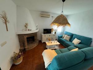 弗里希利亚纳Villa en Frigiliana con piscina, jacuzzi y espectaculares vistas的客厅设有蓝色的沙发和壁炉