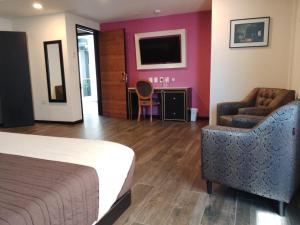 乔卢拉Mansion Azul Cholula的酒店客房配有一张床、一把椅子和一台电视。
