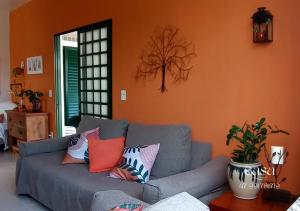 佩尼亚Casa de Praia Penha, Beto Carrero, 500m da Praia da Armação的客厅配有带色彩缤纷枕头的灰色沙发