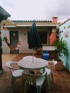 特拉曼达伊Kitnet da Elô的露台上的桌子和遮阳伞