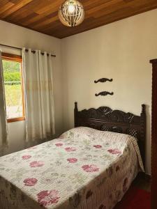 上大瓦尔任Chalé Casa em Vargem Alta的一间卧室设有一张床和一个窗口