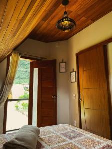 上大瓦尔任Chalé Casa em Vargem Alta的一间卧室设有一张床和木制天花板