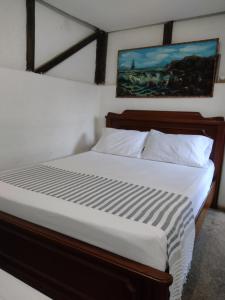 卡利Sapiens house "cabaña del Río"的一间卧室配有一张带白色床单的大床