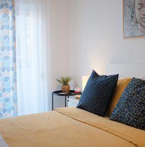 阿尔马达Just4u Apartment的一间卧室配有一张带蓝色枕头的床和一张桌子