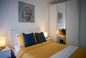 阿尔马达Just4u Apartment的一间卧室配有一张特大号床,提供蓝色和黄色枕头