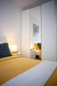 阿尔马达Just4u Apartment的一间卧室配有黄色的床和镜子