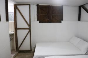 卡利Sapiens house "cabaña del Río"的一间设有床铺和木门的房间