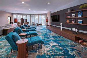 圣安东尼奥圣安东尼奥北部原石橡树万怡酒店的客厅配有蓝色椅子和大地毯