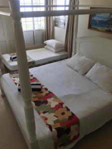 LevukaNew Mavida Lodge的一间卧室配有两张床和一张天蓬床。