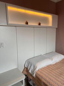 圣佩德罗-达阿尔德亚casa sao pedro da aldeia的一间卧室配有一张位于上面的光线的床