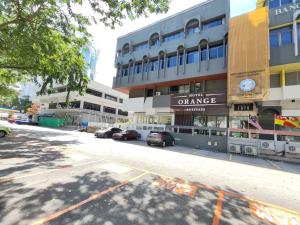 八打灵再也Orange Business Hotel Petaling Jaya的一条空的街道,汽车停在大楼前