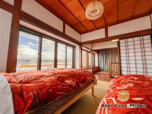 妙高Arai Villa Myoko的一间卧室设有一张床和一个大窗户