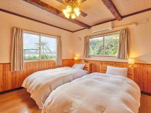 奄美Villa AdanRose Amami - Vacation STAY 06112v的卧室设有两张床,带两个窗户
