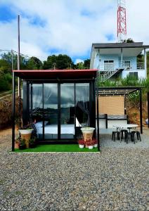 昆达桑SF Homestay的小房子设有玻璃门和桌椅