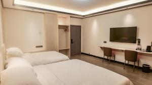 桂林桂林美舍民宿(芦笛岩景区店)的酒店客房设有两张床和一台平面电视。