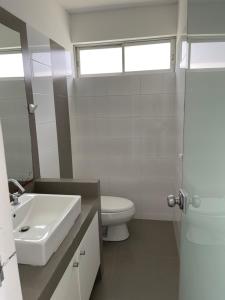 帕拉卡斯Ocean View Apartment的白色的浴室设有水槽和卫生间。
