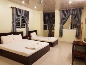 朱笃Hostel Đặng Lợi ホステルダンロイ的一间卧室配有两张床和镜子