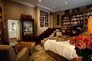 约翰内斯堡The Great Gatsby Houghton的一间设有床铺的房间和一个带书籍的楼梯