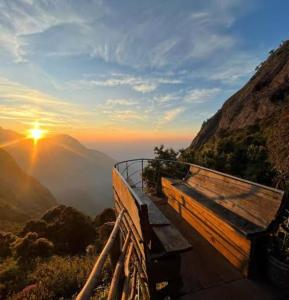 蒙纳Munnar green portico cottage的山顶上长凳,日落