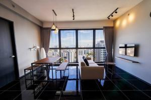 日落洞Urban Suites with Spectacular High Floor View #3BR #03的客厅设有桌子和大窗户