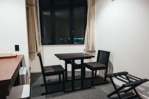 佐贺市TAPSTAY HOTEL - Vacation STAY 35228v的窗户间里的一张桌子和两把椅子