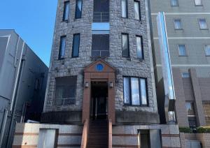 佐贺市TAPSTAY HOTEL - Vacation STAY 35228v的前面有一扇门的高高的砖砌建筑