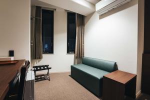 佐贺市TAPSTAY HOTEL - Vacation STAY 35239v的客厅设有绿色沙发和窗户。