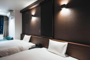 佐贺市TAPSTAY HOTEL - Vacation STAY 35239v的酒店客房,设有两张床,墙上有灯