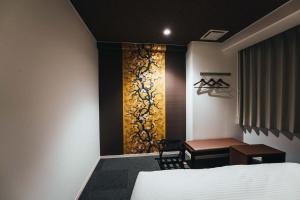 佐贺市TAPSTAY HOTEL - Vacation STAY 35230v的一间卧室配有一张床、一张桌子和一个窗户。
