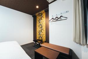 佐贺市TAPSTAY HOTEL - Vacation STAY 35230v的一间卧室配有一张床、一张桌子和一张长凳