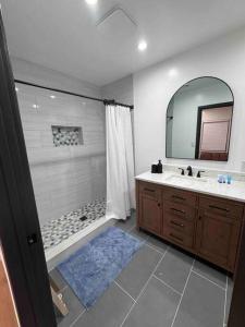 长滩Mid-Century Gem in Long Beach的带淋浴、盥洗盆和镜子的浴室