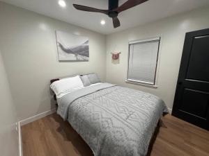 长滩Mid-Century Gem in Long Beach的一间卧室配有一张床和吊扇