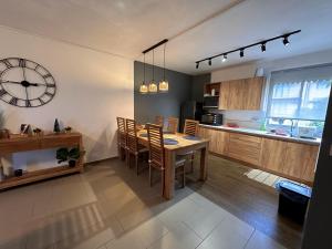 特鲁欧克比赫斯Trou aux Biches Apartment的厨房以及带桌子和时钟的用餐室。