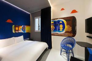 新加坡Hi Hotel Bugis的卧室配有白色的床和蓝色的墙壁