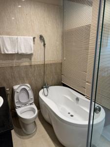 头顿Phúc Đạt Hotel的带浴缸、卫生间和盥洗盆的浴室