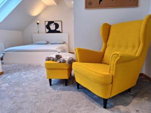 胡伊埃拉尔特Brussels countryside的一间卧室配有黄色椅子和一张床