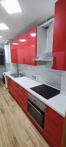 Las CortsLovely Flat Fira Barcelona的厨房配有红色橱柜和炉灶烤箱