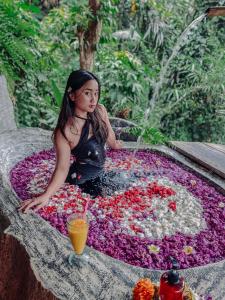 TampaksiringBali Inang Jungle View的坐在花池里的一个女孩,喷泉里