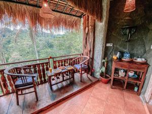 TampaksiringBali Inang Jungle View的一间设有两把椅子、一张桌子和一个窗户的房间