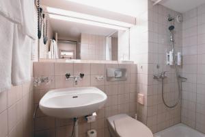 韦因费尔登Hotel Thurgauerhof Self-Check-in的白色的浴室设有水槽和卫生间。