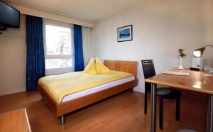韦因费尔登Hotel Thurgauerhof Self-Check-in的一间卧室配有一张床、一张桌子和一张桌子