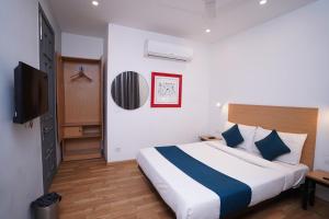新德里Hotel Mira Residency- Outer Ring Road, Paschim Vihar的一间卧室配有一张床和一台平面电视