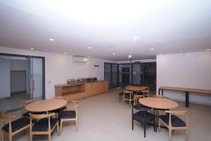 新德里Hotel Mira Residency- Outer Ring Road, Paschim Vihar的一个带桌椅的教室和厨房