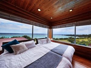今归仁村长冈海滩度假村 的一间卧室设有一张大床和大窗户