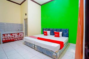 Tambak-kidulOYO 91583 D’cost Green Syariah的一间卧室配有一张带绿色墙壁的床