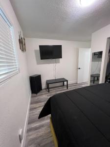 拉斯维加斯Cozy and Spacious Home的一间卧室配有一张床和一台平面电视