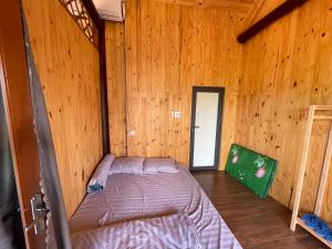 Dak LakTHE LAND OF LOVE Homestay - Venuestay的小木屋内一间卧室,配有一张床