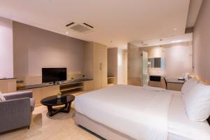 曼谷素可泰住鲁安吕迪旅馆的卧室配有一张白色的大床和一张沙发。