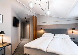 塔林Rija Fonnental Design Hotel Tallinn的一间卧室配有白色的床和两盏灯